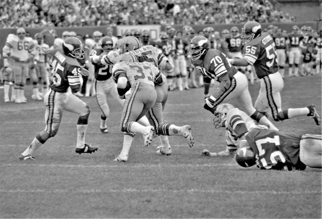 Current image: A vintage capture of athletes competing in a high-energy football game.